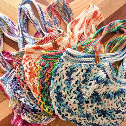 mesh bags perfect for markets handmade crochet in a variety of colours including pink green purple multicolour orange bright rainbow blue with faux leather brand tags